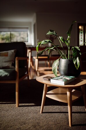 A cozy living room with a wooden coffee table, a potted plant, and a book.