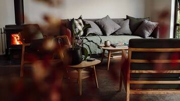 A cozy living room with a sofa, chairs, a coffee table, and a fireplace.