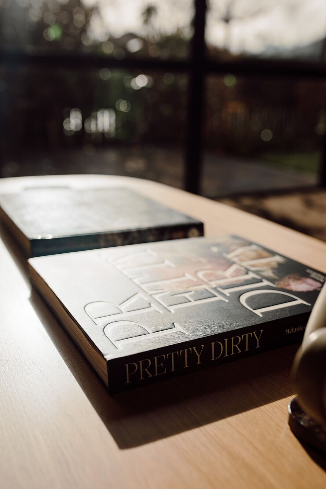 Un livre intitulé « Pretty Dirty » posé sur une surface en bois.