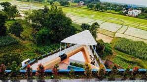 A terrace with a view of terraced fields and a white structure with a roof. - MH Club And Resorts (Nagri)