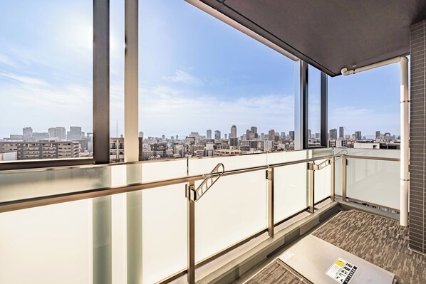 A high-rise building with a view of a city skyline. - Apartment Hotel 11 Dotonbori 9 (Osaka-shi)