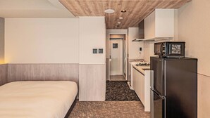 A hotel room with a bed, a kitchenette, and a bathroom. - Apartment Hotel 11 Dotonbori 9 (Osaka-shi)