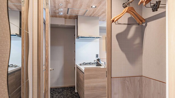 A modern bathroom with a wooden vanity, a mirror, and a hanging wooden hanger. - Apartment Hotel 11 Dotonbori 9 (Osaka-shi)