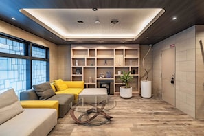 A modern living room with a sofa, a glass coffee table, and a fireplace. - Apartment Hotel 11 Dotonbori 9 (Osaka-shi)