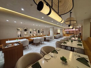 Un interior de restaurante con varias mesas, cabinas y una pared que exhibe varios objetos decorativos.