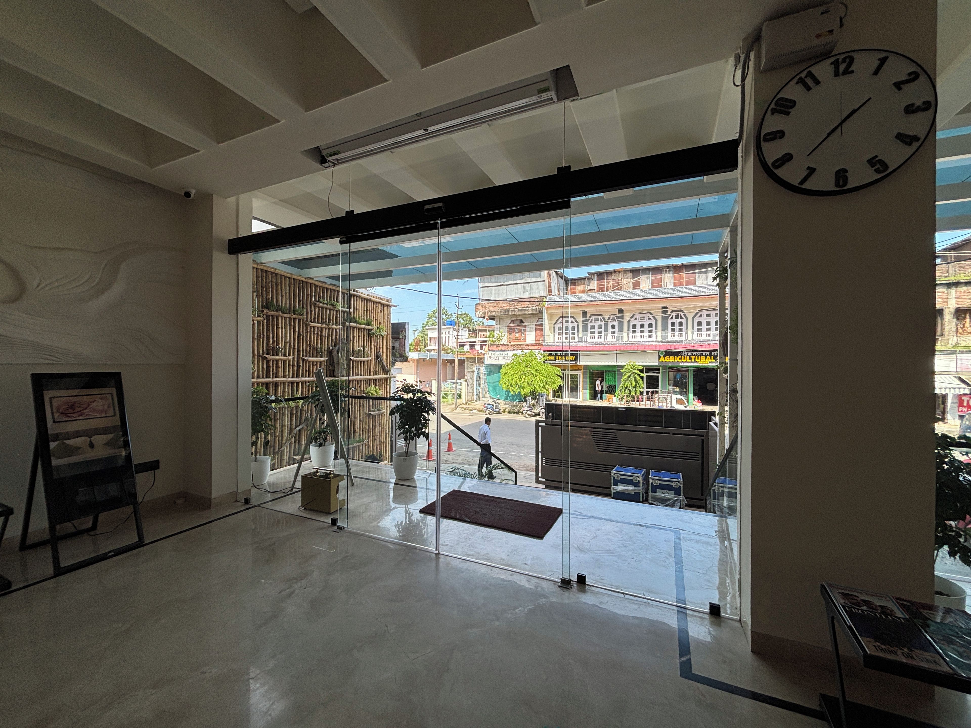 Um espaço interior com uma janela grande, um relógio e vista para a rua.