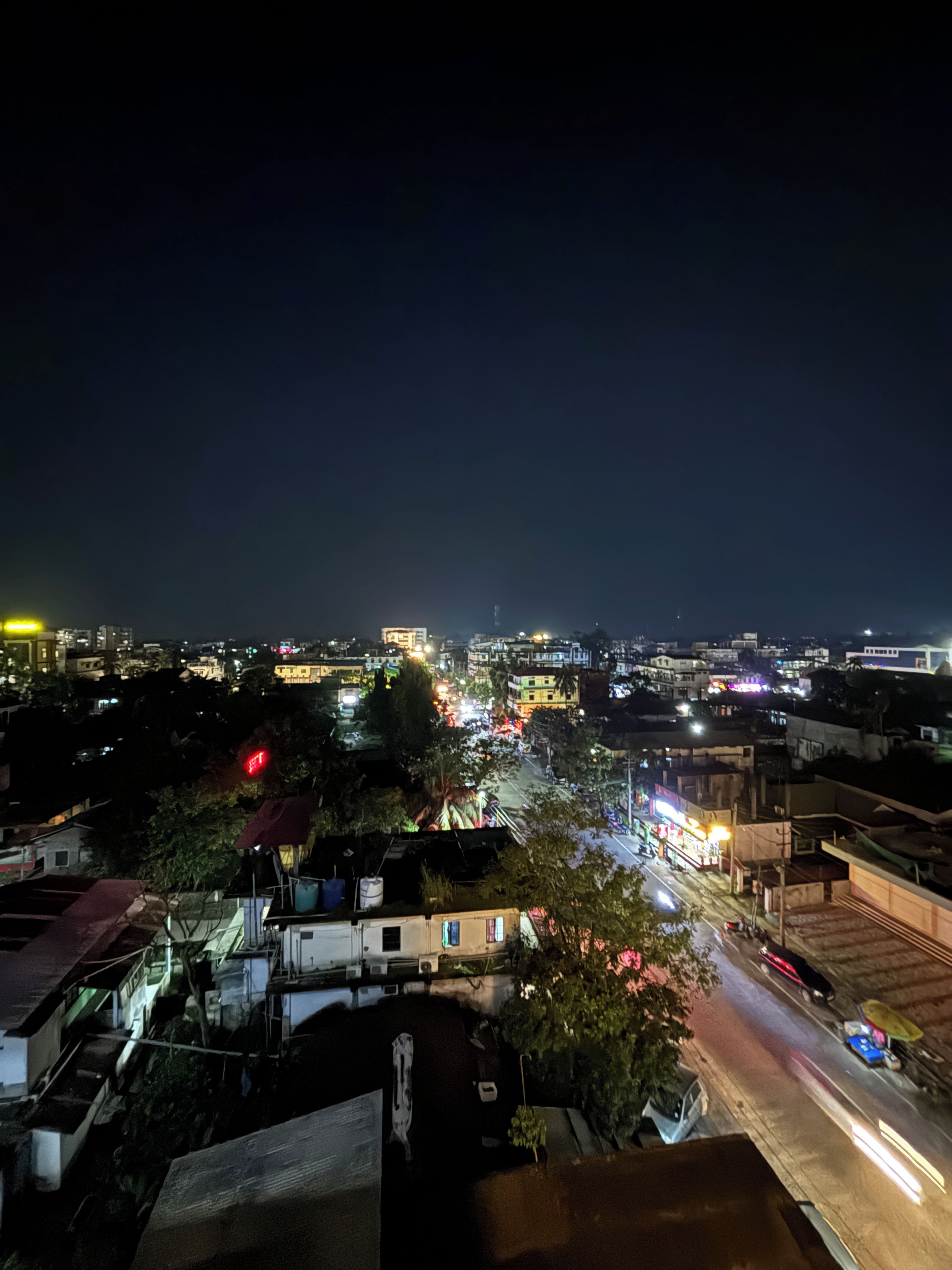 A nighttime cityscape with buildings, roads, and traffic lights.