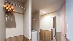 Un baño moderno con lavadora blanca, paneles de madera y un espejo.