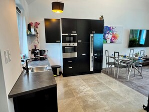 Cafetera o tetera, frigorífico, horno y placa de cocina