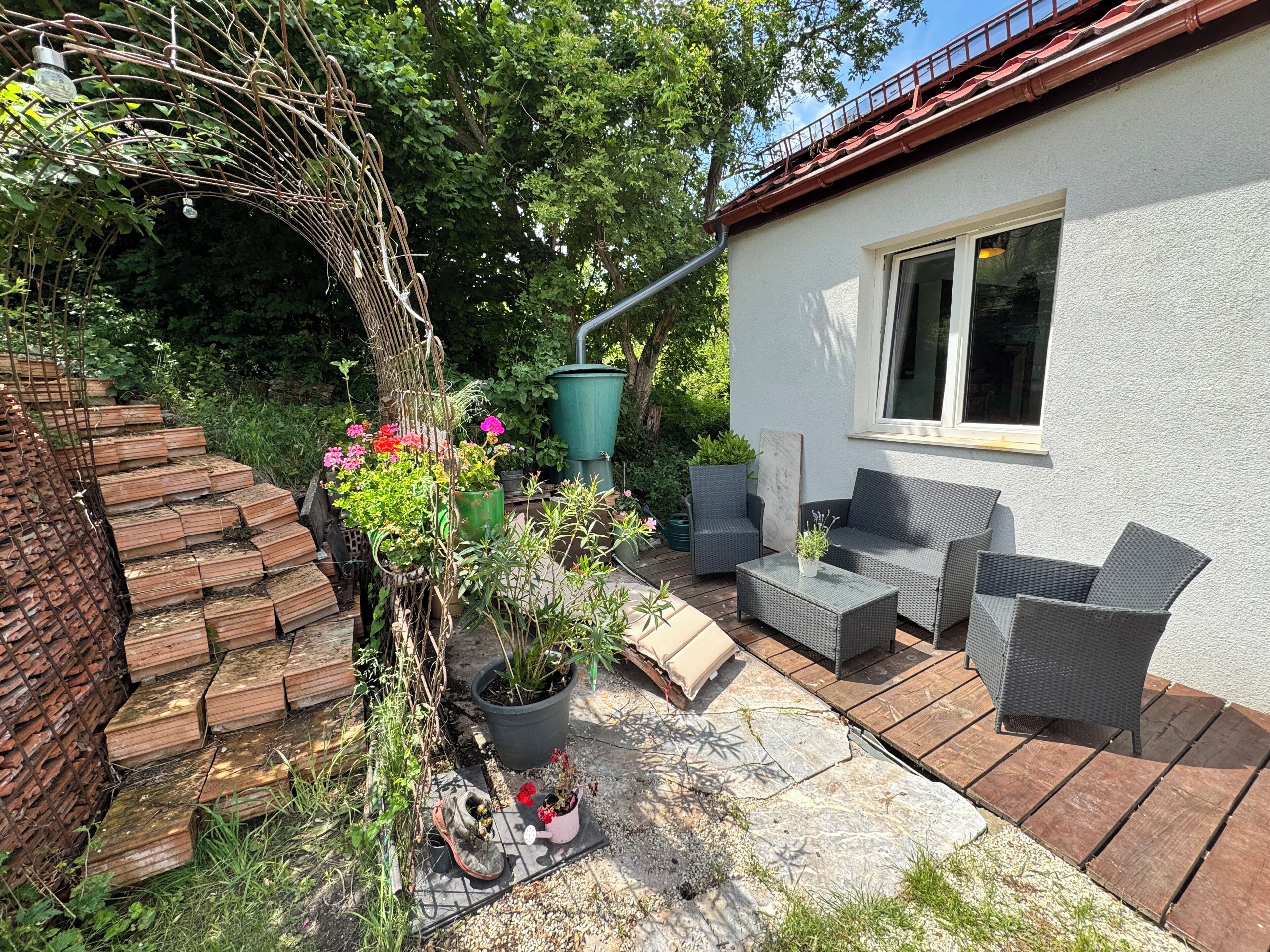 A patio area with outdoor furniture, a brick wall, and a window.