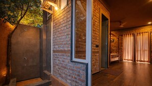 A modern interior with a brick wall, a glass door entrance, and a wooden floor.