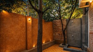 Uma área de spa com parede de tijolos, uma árvore e piso revestido.