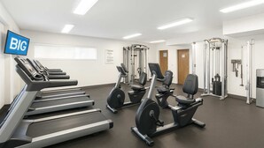 A fitness center with treadmills, elliptical machines, and weightlifting equipment. - Waikiki 2BR 2BA 34th Fl Ocean View Sunset/Sunrise (Honolulu)