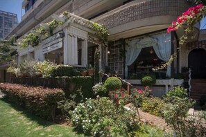 A traditional building with a garden in front, featuring a variety of plants and flowers. - Waikiki 2BR 2BA 34th Fl Ocean View Sunset/Sunrise (Honolulu)