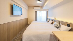 A hotel room with a bed, bedside table, wall-mounted TV, air conditioning unit, and a window with curtains. - Apartment Hotel 11 Hanazono 1 (Osaka-shi)