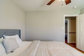 A bedroom with a bed, a ceiling fan, and a door leading to another room. - Spacious 4BR/2.5BA Pet-Friendly Home in Clayton, NC – Minutes from Raleigh, Sleeps 8 (Clayton)