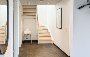 A hallway with a staircase, a white baby changing station, and a framed picture on the wall. - Gorgeous home in Rømø with sauna (Rømø)