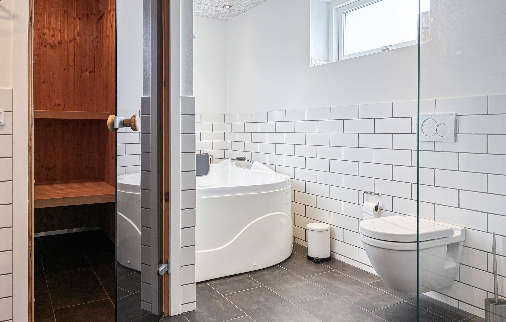 Une salle de bain moderne avec une baignoire sur pieds, des toilettes et une douche à parois de verre.