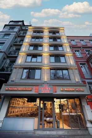 A hotel with a restaurant on the ground floor, multiple balconies, and a classic architectural style. - CZN Burak Hotel (Istanbul)