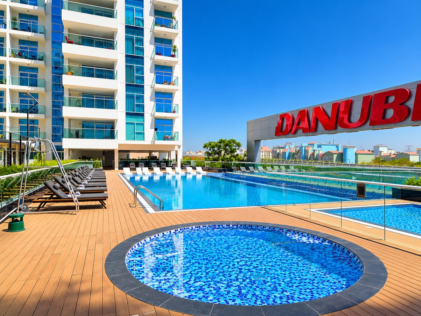 A hotel pool area with lounge chairs and a large pool.