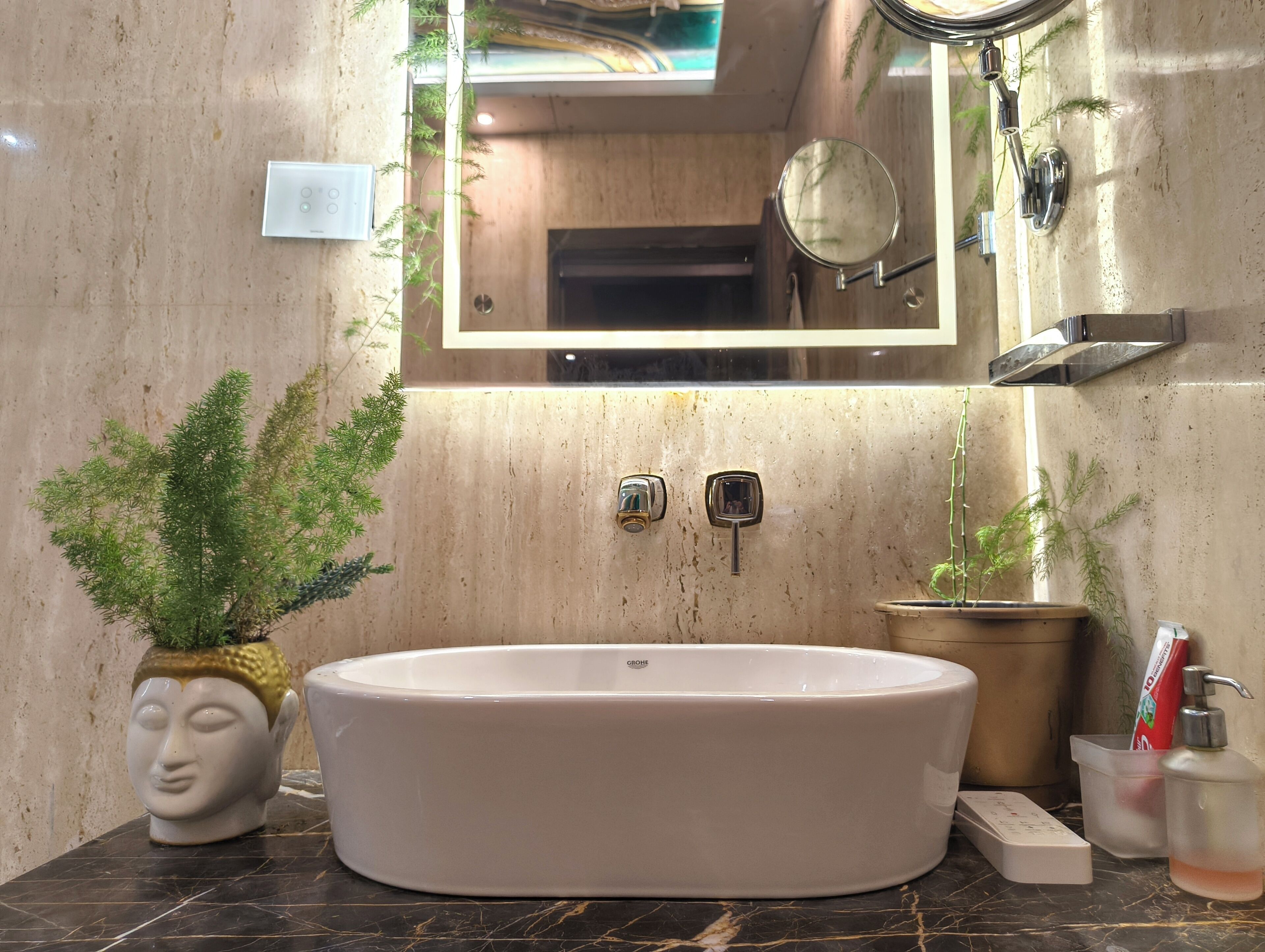 Une salle de bain avec une baignoire sur pieds, un miroir et une plante en pot.