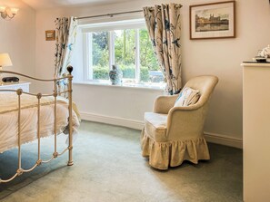 A bedroom with a four-poster bed, a chair, a window with curtains, a vase, and a framed picture on the wall. - 1 bedroom accommodation in Clitheroe and the Ribble Valley (Clitheroe and the Ribble Valley)