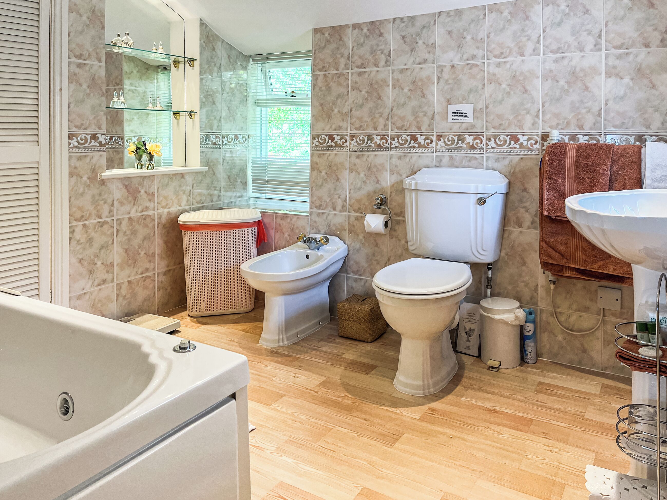 A bathroom with a bathtub, a bidet, a toilet, and a sink.