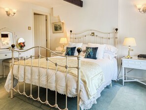 A neatly arranged bedroom with a classic metal bed frame, white bedding, and a bedside table with a lamp. - 1 bedroom accommodation in Clitheroe and the Ribble Valley (Clitheroe and the Ribble Valley)