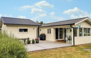 A two-story building with a covered patio area, a flag, and a number '5C' on the facade. - 3 bedroom cozy home in Skummeslövstrand (Skummeslövstrand)