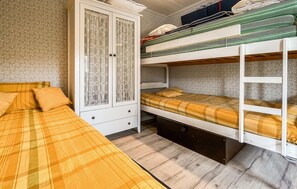 A bunk bed with a lower bunk, a wardrobe with glass doors, and a bed with a plaid bedspread. - 3 bedroom cozy home in Skummeslövstrand (Skummeslövstrand)