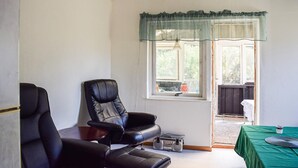 A room with a black leather chair, a small table, a radio, and a window with a curtain. - 1 bedroom beautiful home in Mörrum (Mörrum)