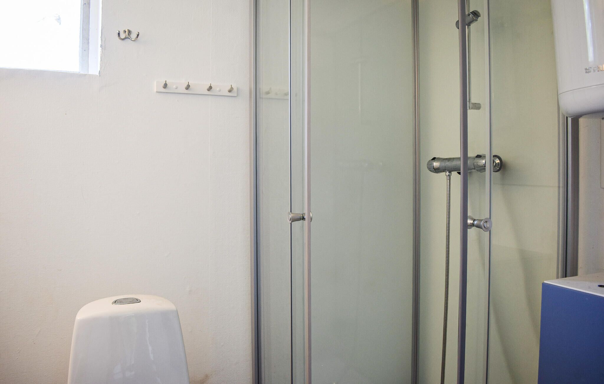 Ein Badezimmer mit Duschkabine aus Glas, einer weißen Toilette und einem an der Wand befestigten Handtuchhalter.