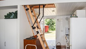A kitchen with a wooden ladder leaning against the ceiling, a refrigerator, and a door leading outside. - 1 bedroom beautiful home in Mörrum (Mörrum)