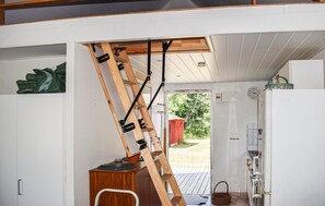 A kitchen with a wooden ladder leaning against the ceiling, a refrigerator, and a door leading outside. - 1 bedroom beautiful home in Mörrum (Mörrum)