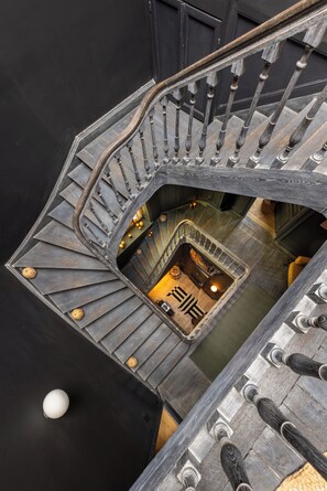 Un escalier en colimaçon avec une rampe en bois menant à un niveau inférieur.