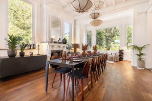 A spacious dining area with a long table set for multiple people, surrounded by wooden chairs.