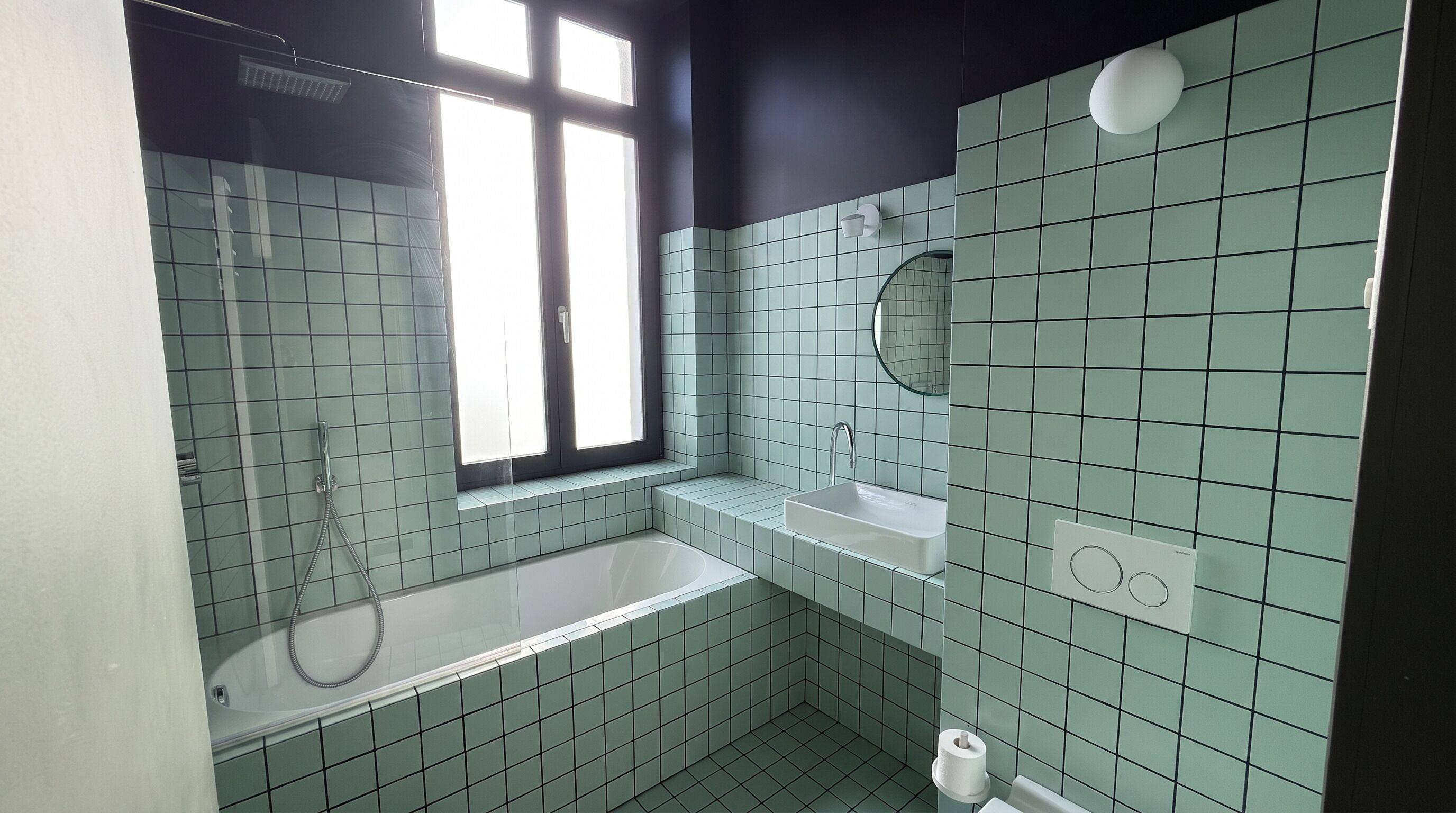 Ein Badezimmer mit einer Badewanne, einem Waschbecken und einem Fenster.