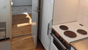 Una cocina compacta con refrigerador, estufa y horno.