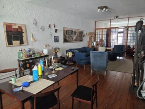 A living room with a blue sofa, wooden dining table, and various decorative items. - Hosted Loft in SoHo ! (New York)