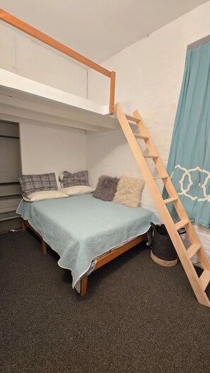 A bunk bed with a wooden ladder, a blue blanket, and two pillows. - Hosted Loft in SoHo ! (New York)