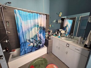 A bathroom with a bathtub, shower, and a vanity with a mirror. - Hosted Loft in SoHo ! (New York)