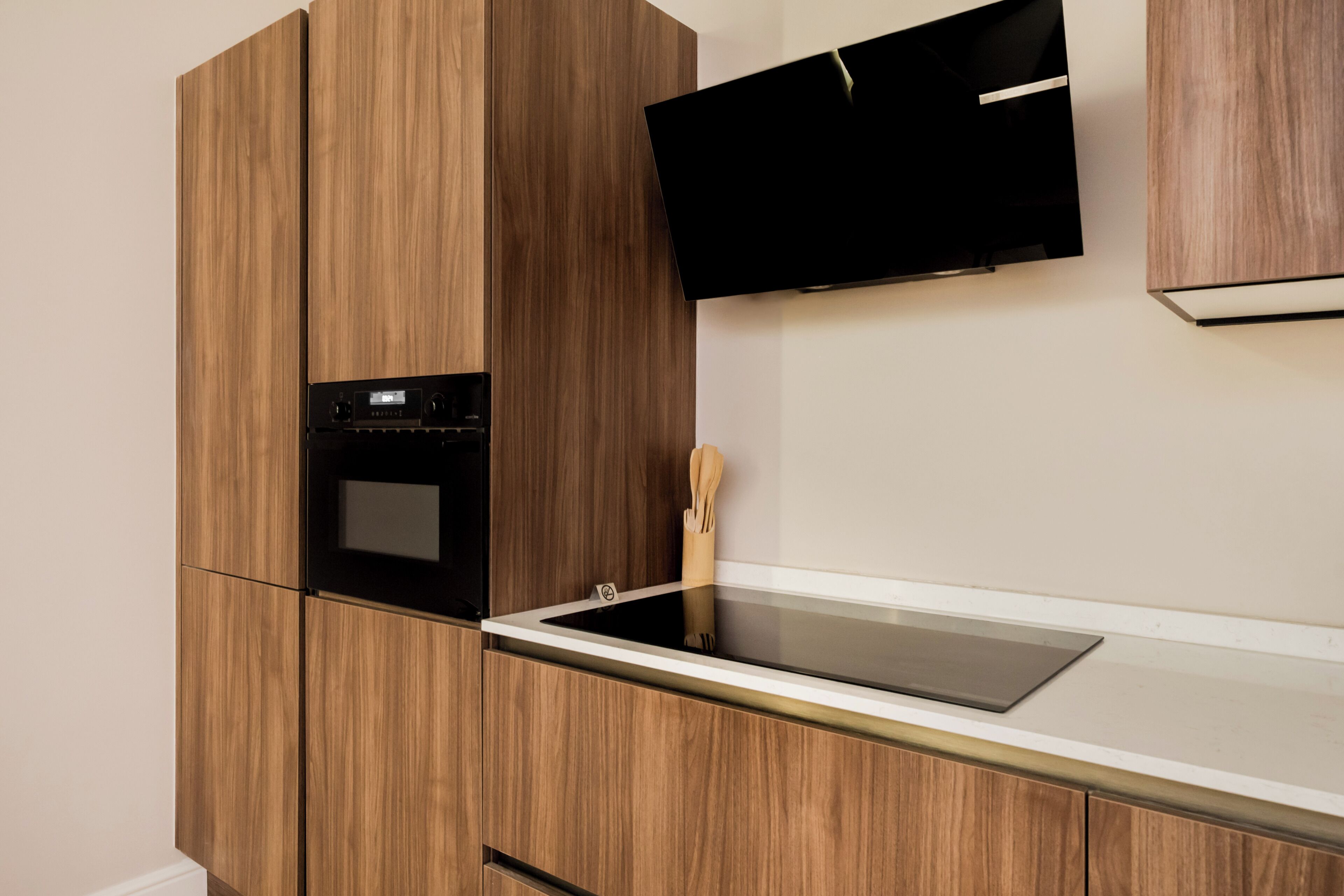 A kitchen with wooden cabinets, a built-in oven, a microwave, and a stainless steel countertop.