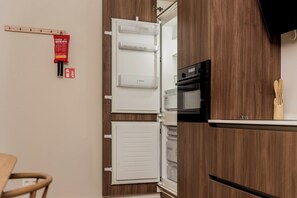 A kitchen with a white refrigerator, a microwave, and wooden cabinets. - New apartment in downtown Antwerp for 6 people (Antwerpen)