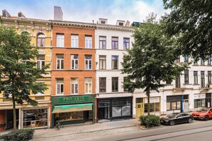 A row of multi-story buildings with various storefronts, including a visible shop named 'PRO ARTE' with a green awning. - New apartment in downtown Antwerp for 6 people (Antwerpen)