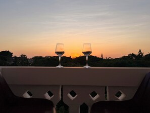 Two wine glasses on a balcony with a sunset view. - 2-bedroom apartment with AC, 5 mins from Diani Beach (Diani Beach)