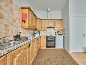 Eine Küche mit Holzschränken, einer Mikrowelle, einem Toaster und einem Geschirrspüler.