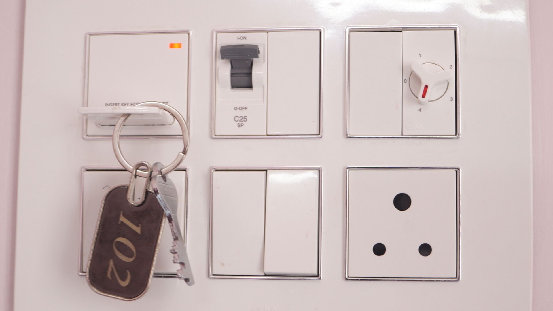 Ein an der Wand montiertes Stromverteilerkästchen mit Schaltern, einem Schlüsselloch und einem Schlüsselbund.