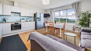 A modern kitchen with white cabinets, a built-in oven, and a stainless steel refrigerator. - No.6 Dunluce Park Apartments - UK52047 (Portrush)