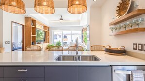 A modern kitchen with a central island, built-in cabinetry, and a view to the outside. - Deluxe 2BD corner unit & Rooftop Pool in Versalles 2BD Condo for rent in Versall (Puerto Vallarta)