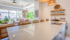 A modern kitchen with a large island, built-in appliances, and a view of the outdoors. - Deluxe 2BD corner unit & Rooftop Pool in Versalles 2BD Condo for rent in Versall (Puerto Vallarta)
